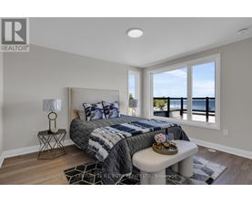 A bedroom with a large bed and a view of the ocean.