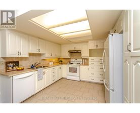 A kitchen with white cabinets and appliances.