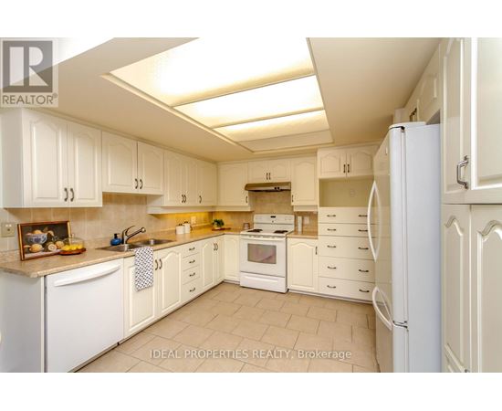A kitchen with white cabinets and appliances.