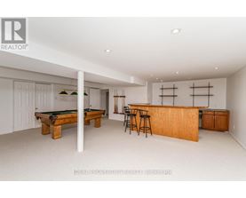A room with a pool table and bar area.