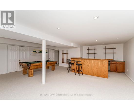 A room with a pool table and bar area.