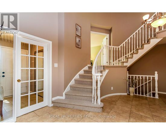 A staircase with a white railing and beige carpeted steps leads to a second floor.