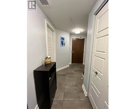 A hallway with a black cabinet and a brown door.