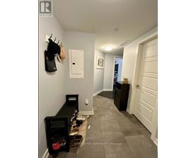 A hallway with a coat rack, a shoe rack, and a white door.
