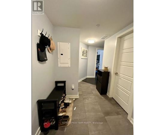 A hallway with a coat rack, a shoe rack, and a white door.