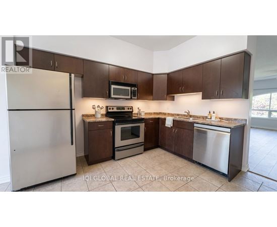 A kitchen with brown cabinets and stainless steel appliances.