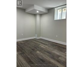 A room with wooden flooring and a window.