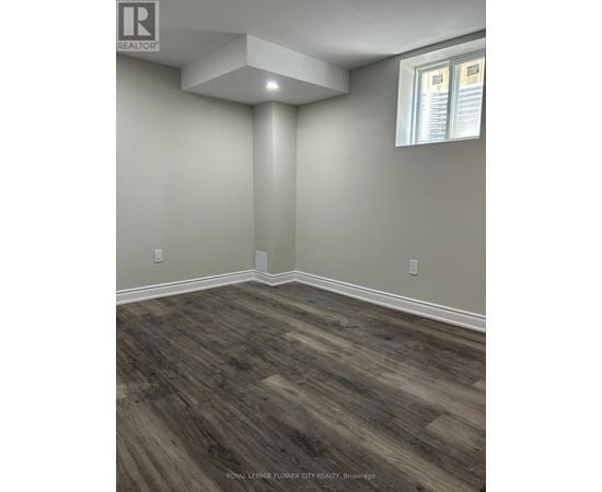 A room with wooden flooring and a window.
