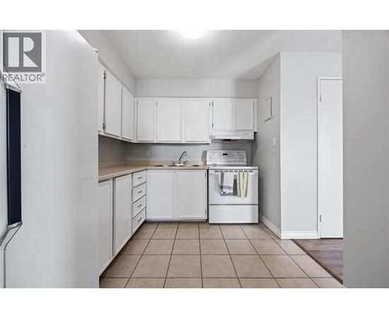 A kitchen with white cabinets and a dishwasher.