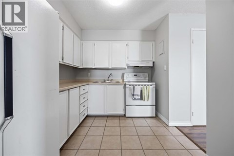 A kitchen with white cabinets and a dishwasher.