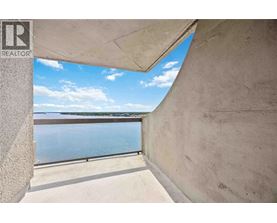 A view from a window looking out to a pool and a body of water.