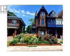 A large house with a blue front door and a flower bed in front.