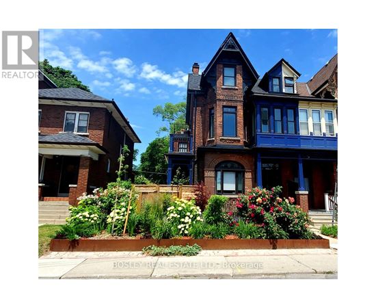 A large house with a blue front door and a flower bed in front.