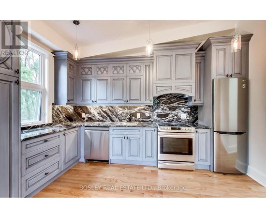 A kitchen with a granite countertop and stainless steel appliances.