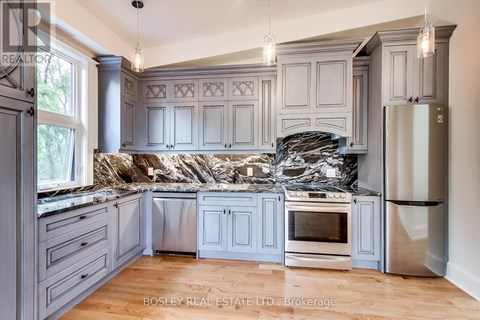 A kitchen with a granite countertop and stainless steel appliances.