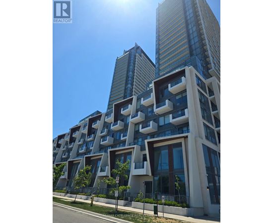 A modern building with a unique design stands tall against a clear sky.