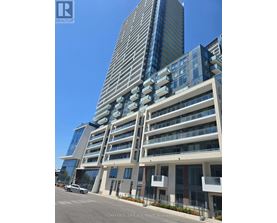 A tall building with a glass facade stands next to a shorter building with a white facade.