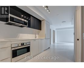 A modern kitchen with white cabinets and stainless steel appliances.