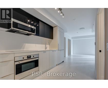 A modern kitchen with white cabinets and stainless steel appliances.
