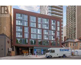 A Canpar delivery truck is parked in front of a multi-story building.