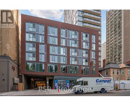 A Canpar delivery truck is parked in front of a multi-story building.