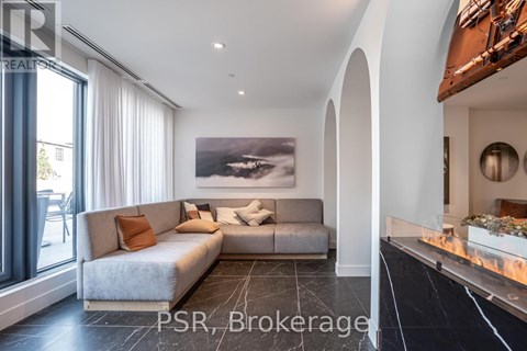 A modern living room with a grey sofa and a large painting on the wall.