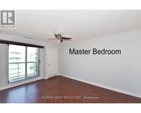 A master bedroom with a sliding glass door leading to a balcony.