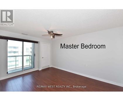 A master bedroom with a sliding glass door leading to a balcony.