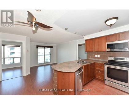 A kitchen with wooden cabinets and a fan on the ceiling.