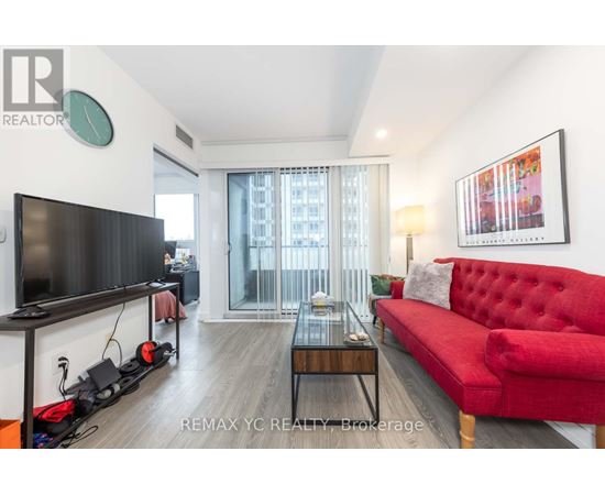 A living room with a red couch and a flat screen TV.