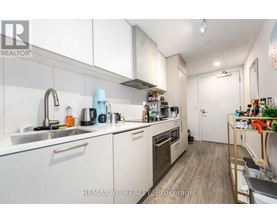 A kitchen with white cabinets and a sink.