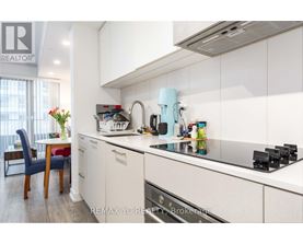 A kitchen with white cabinets and a blue chair.