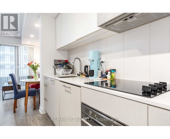 A kitchen with white cabinets and a blue chair.