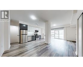 A spacious kitchen with a refrigerator, oven, and sink.
