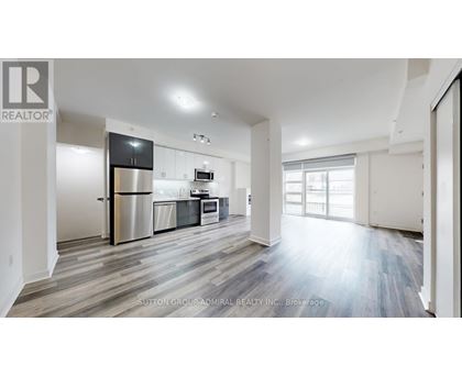 A spacious kitchen with a refrigerator, oven, and sink.