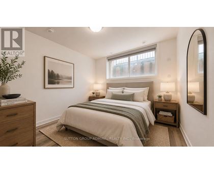 A well-lit bedroom with a large bed and a framed picture on the wall.
