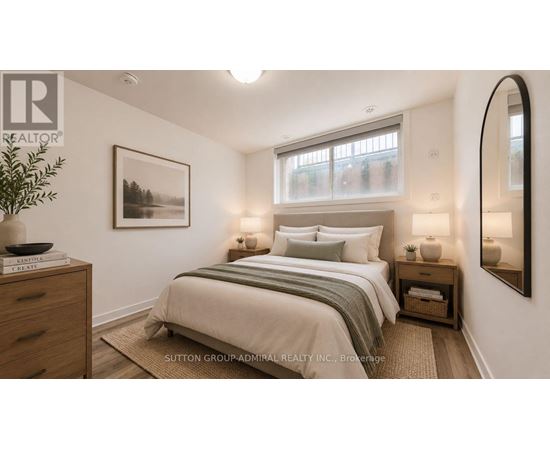 A well-lit bedroom with a large bed and a framed picture on the wall.