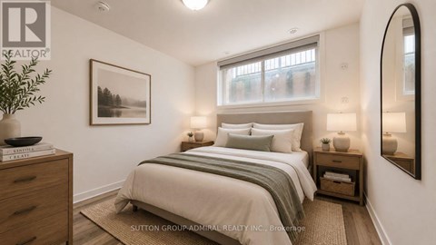 A well-lit bedroom with a large bed and a framed picture on the wall.