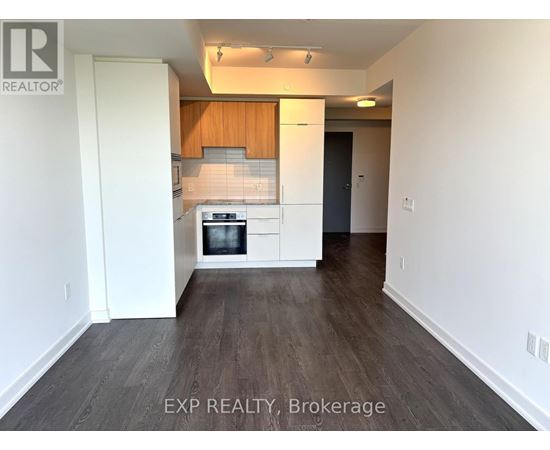 A kitchen with white cabinets and a wooden backsplash.