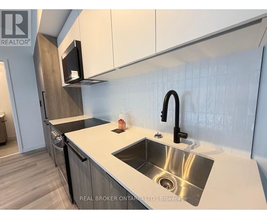 A modern kitchen with a sink and a microwave above it.