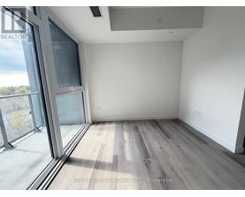 A room with a large window and wooden flooring.