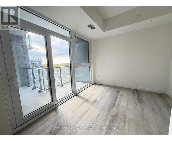 A room with a view of a balcony through a glass door.