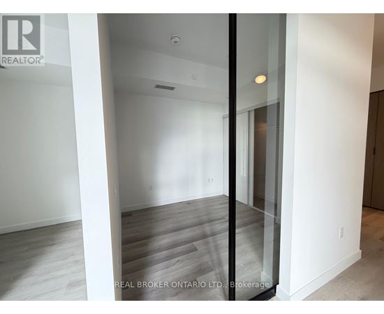 A room with a glass door and wooden flooring.