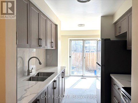 A kitchen with a sink and a refrigerator.
