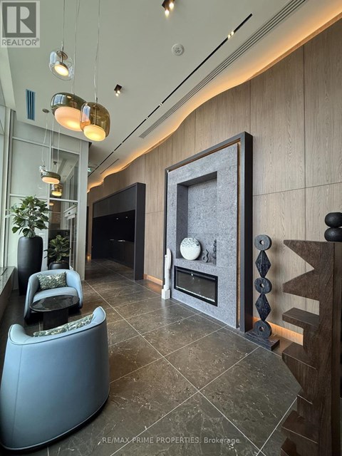 A modern living room with a grey sofa and a fireplace.