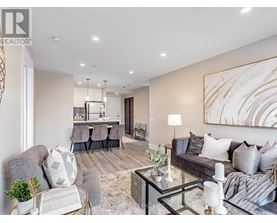 A modern living room with a grey sofa, a glass coffee table, and a large abstract painting on the wall.