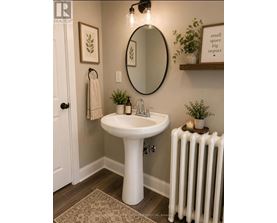 A bathroom with a white pedestal sink and a white radiator.