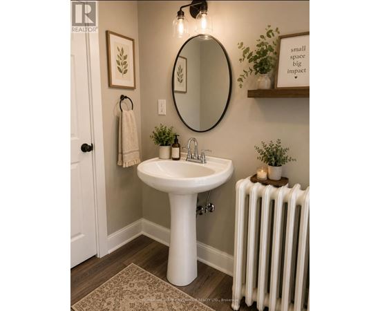 A bathroom with a white pedestal sink and a white radiator.