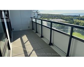 A balcony with a view of a parking lot and trees.