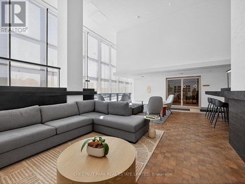 A modern living room with a grey sofa and a coffee table with a plant on it.